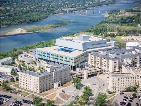 Large hospital campus with a river running through it. The buildings are tall and the sky is blueの写真素材