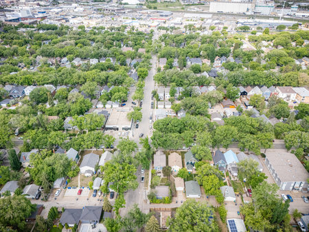 View of a residential neighborhood with many houses and trees. The houses are mostly white and the trees are greenの写真素材
