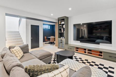 Living room with a large flat screen TV and a couch. The room has a modern and comfortable feel to itの写真素材