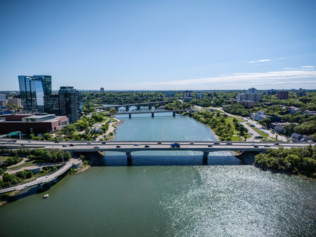 City with a river running through it and a bridge over the water. The bridge is busy with cars and trucksの写真素材