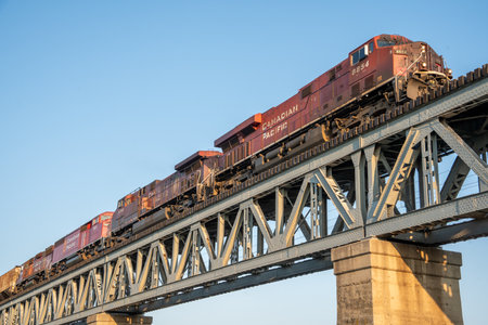 Train is crossing a bridge. The bridge is made of metal and is very long