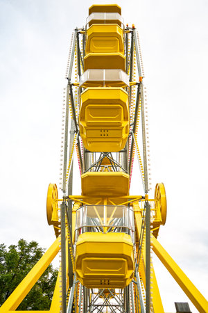 Yellow Ferris wheel with a white background. The Ferris wheel is the main focus of the imageの写真素材