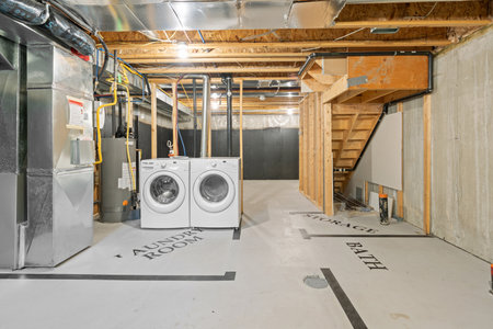 Laundry room with a washer and dryer. The washer is white and the dryer is silver