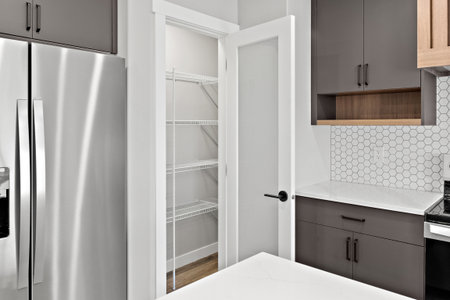 Kitchen with a white tile backsplash and a silver refrigerator. The refrigerator is on the left side...