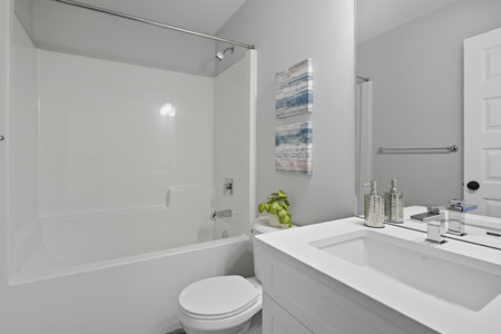 Bathroom with a white toilet and sink. The bathroom is clean and well-maintained