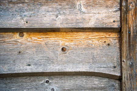 The wood grain is rough and the wood is old. The wood grain is visible in the background