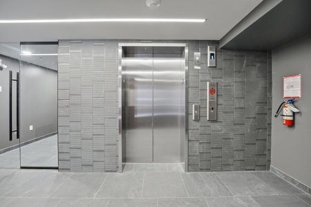 Silver and grey elevator with a red and white sign on the wall.