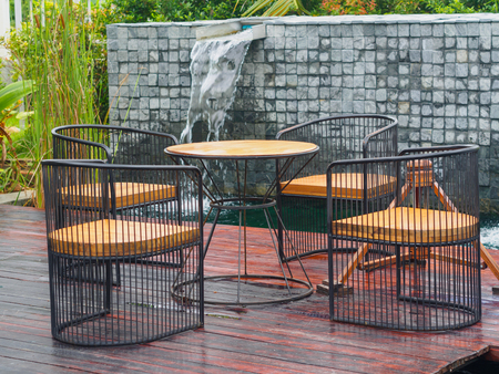 wooden and steel of Patio Furniture set on brown wooden, green grass field and water or river backgroundの写真素材