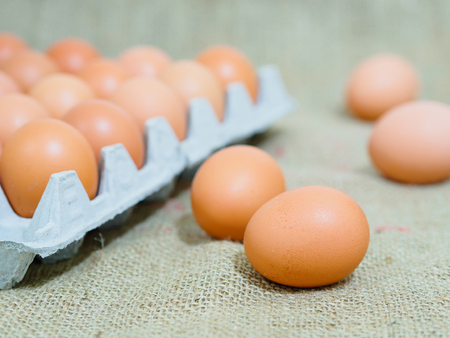 eggs container on brown hemp sack texture backgroundの写真素材
