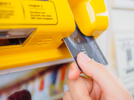 Hand is holding the credit card and insert to the machineの写真素材