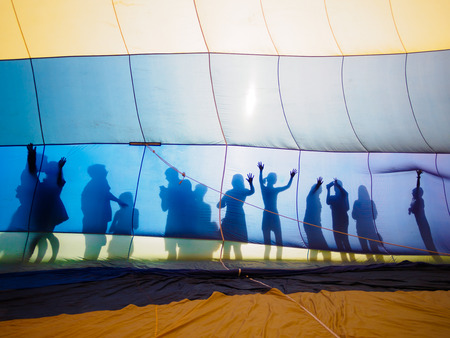 Hot air balloon and silhouette of peopleの写真素材