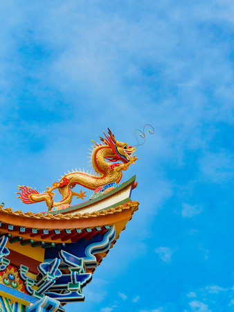 Golden Dragon sculpture on the roof with beautiful color and blue sky backgroundの写真素材