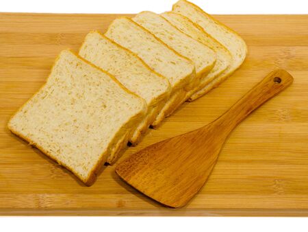Side view of slices of toast bread on breadboard wooden, isolated on white backgroundの写真素材