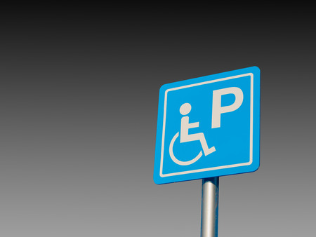 Disabled parking space and wheelchair way sign and symbols on a pole warning motorists isolate on gradient Black and white backgroundの写真素材