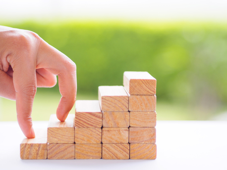 Women hand finger walk on stacked wooden block like stairs. Business development and growth concept.の写真素材