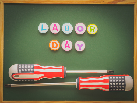 Labor day background concept - many handy tools with labor day text on blackboard background top viewの写真素材