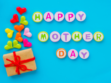 mother's day concept.  HAPPY MOTHER DAY alphabet with colorful heart and gift on blue backgroundの写真素材