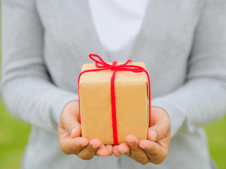 Hands holding beautiful gift box, female giving gift, Christmas holidays and greeting season concept, shallow dofの写真素材