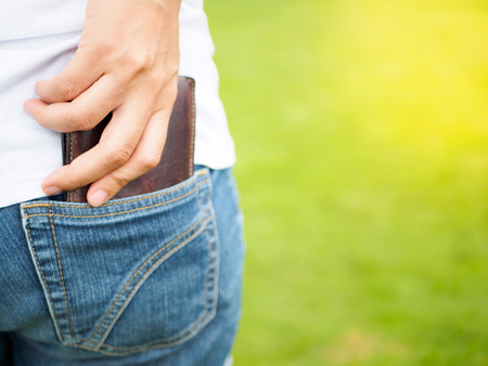 Women's hand taking wallet from his own pocketの写真素材