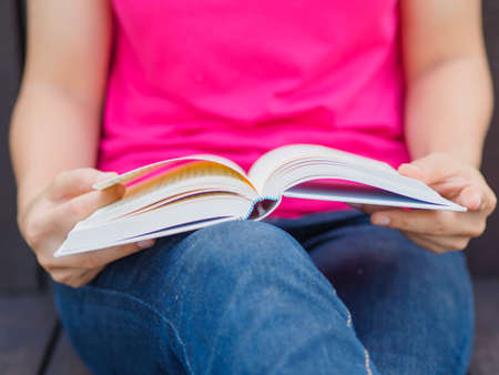 Woman with book sitting on wooden floorの写真素材