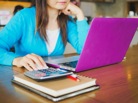 Pretty Young woman using laptop computer. Female working on laptop in an indoor cafe.の写真素材