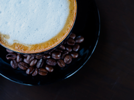 closeup cappuccino coffee on black cut with coffee bean on dark backgroundの写真素材