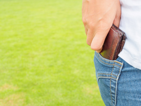 Women's hand taking wallet from his own pocketの写真素材