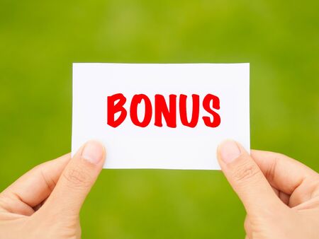 Bonus card in hand with bokeh backgroundの写真素材