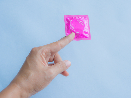 Hand holding condom and sexy legs,selective focus, save sex image.の写真素材
