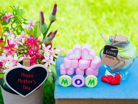 mother's day concept. MOM alphabet with marshmallow in the shape of heart and flower on background