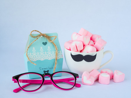 Father's day concept. Sweet love box with glasses and  sweet marshmallow in the shape of heart in cup with black Mustache on white backgroundの写真素材