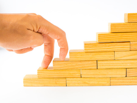 Women hand finger walk on stacked wooden block like stairs. Business development and growth concept.の写真素材