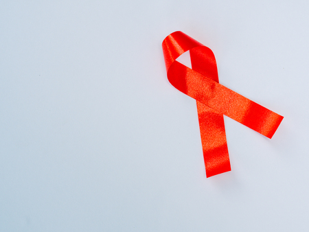 World AIDS day concept. red ribbon on white paper