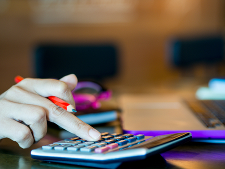 woman working with calculator, business document and laptop computer notebook