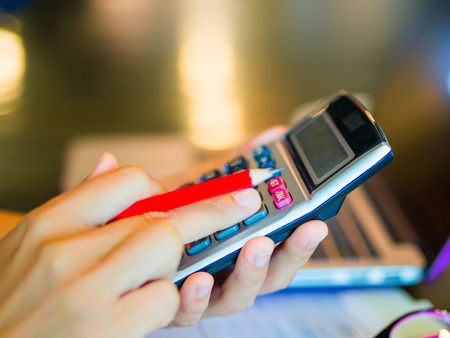 woman working with calculator, business document and laptop computer notebookの写真素材