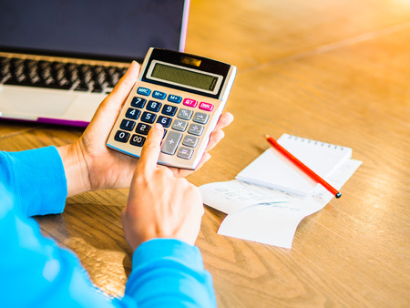 woman working with calculator, business document and laptop computer notebookの写真素材