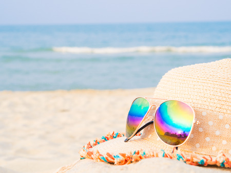 hat and sunglasses on the beach with sea  backround, Concept of summer travelingの写真素材