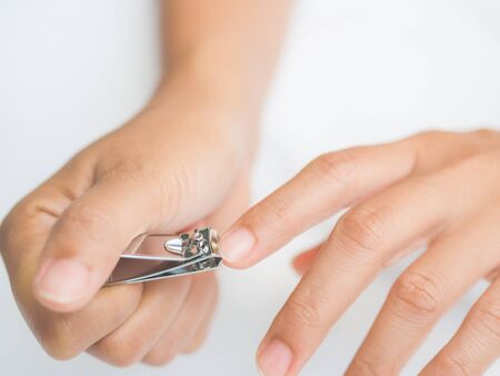 Closeup of a woman cutting nails, health care concept.の写真素材