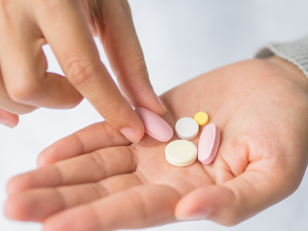 Closeup woman hand holding a pill. Healthcare, medical supplements conceptの写真素材