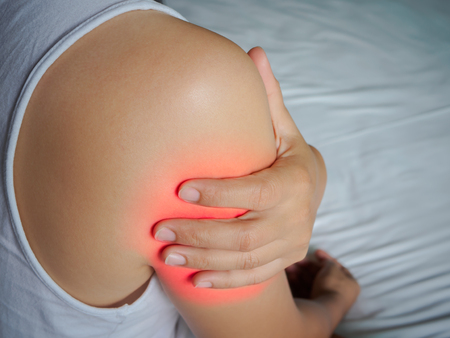 Closeup young woman suffering from pain in arm. Healthcare concept.の写真素材