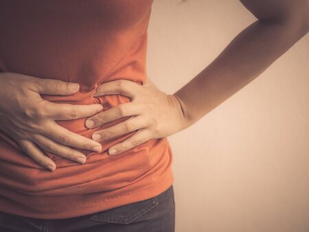 Young beautiful woman having painful stomachache.Chronic gastritis. Abdomen bloating concept.