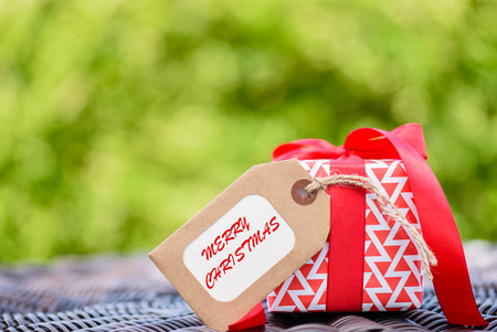 Closeup a gift box with red ribbon. Holidays, present, christmas, and happiness concept.の写真素材