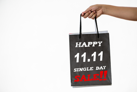Hand holding shopping bags with tags sale for Chinese online festival, 11.11 single day sale concept.の写真素材