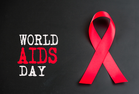 Closeup red ribbon awareness on black background  for World Aids day campaign.