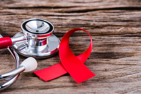 Red ribbon awareness and stethoscope on wooden background  for World Aids day campaign.の写真素材