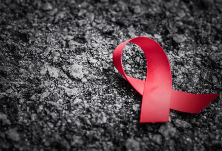Red ribbon awareness  on dark background  for World Aids day campaign.の写真素材