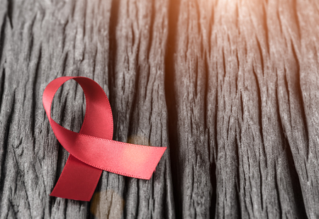 Red ribbon awareness on wooden background  for World Aids day campaign.の写真素材