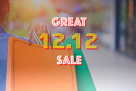 Woman holding shopping bags in the shopping mall as background with 12.12 great sale text concept.の写真素材