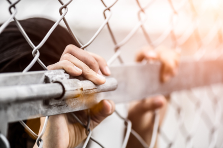 Woman hand holding on chain link fence for remember Human Rights Day concept. Woman hand holding on chain link fence for remember Human Rights Day concept.