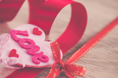 LOVE text and red hearts on another pink heart with red ribbon. Happy Valentine's Day concept.の写真素材